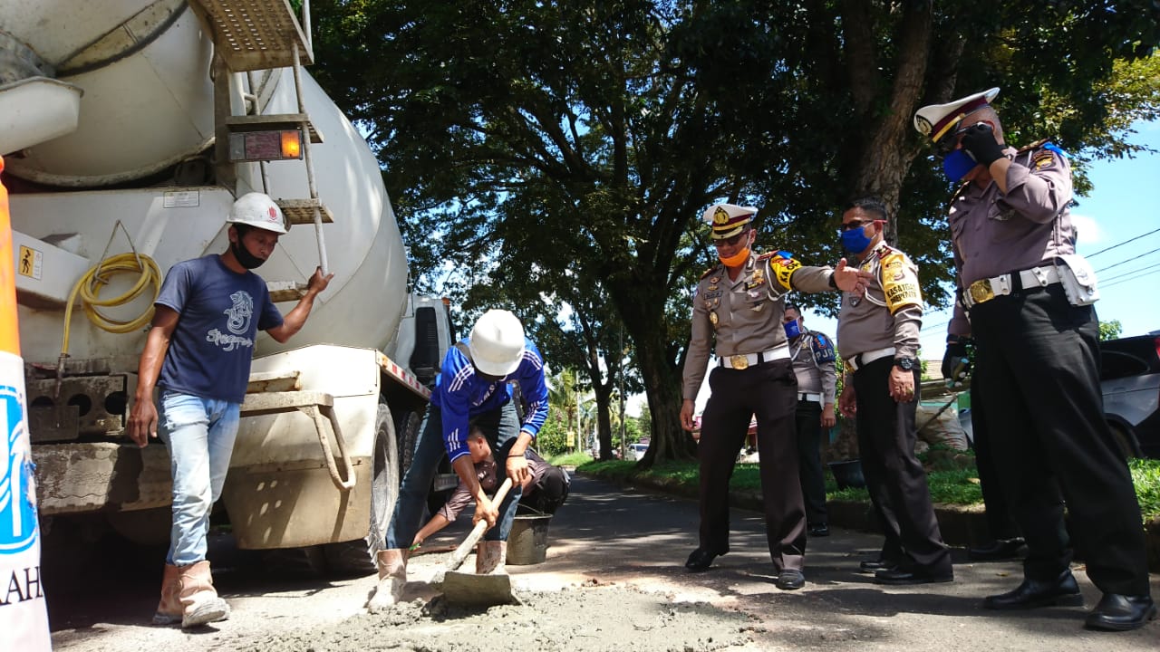 Polisi Bersama Masyarakat Tambal Jalan Berlubang