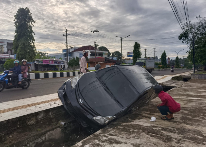 Mobil Berplat Jawa Barat Hantam Trotoar dan Masuk Parit di Jalan Depati Payung Negara